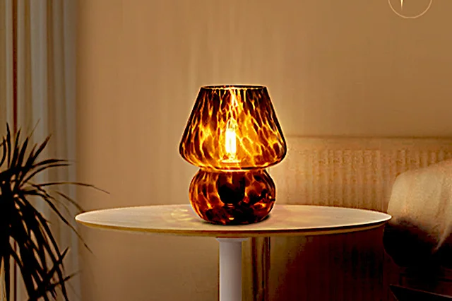 A dark brown & black glass mushroom lamp on a table